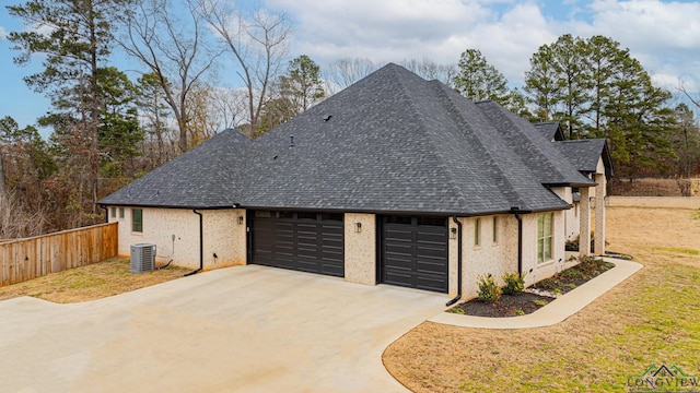 view of property exterior featuring a yard, central AC, and a garage