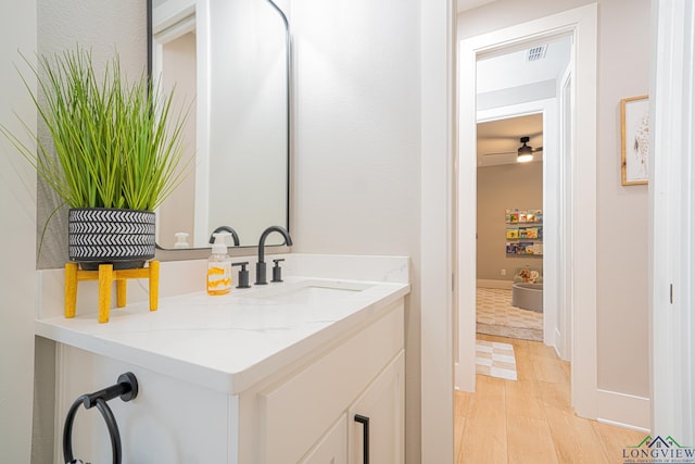 bathroom with ceiling fan, hardwood / wood-style floors, and vanity