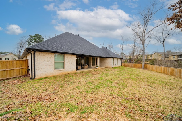 rear view of house with a patio and a lawn