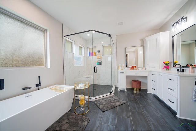 bathroom with vanity and shower with separate bathtub