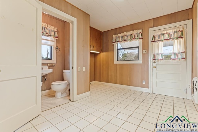 tiled entrance foyer featuring wood walls