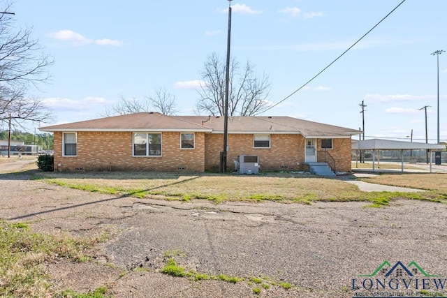 back of property with cooling unit, brick siding, and crawl space