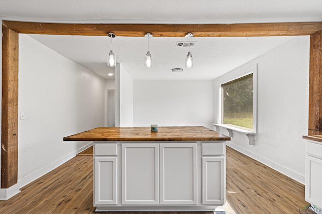 kitchen featuring pendant lighting, light hardwood / wood-style floors, white cabinetry, and butcher block counters