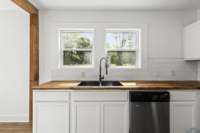 kitchen with white cabinetry, sink, wood counters, stainless steel dishwasher, and decorative backsplash