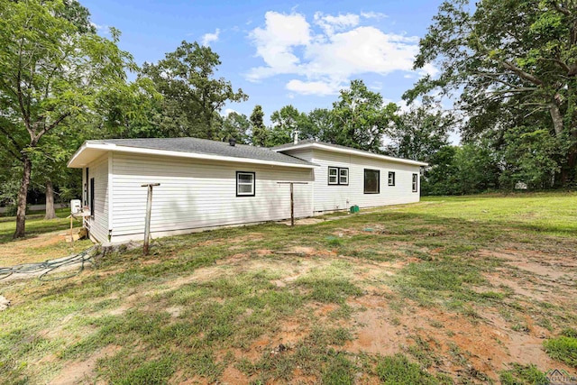 rear view of house featuring a lawn