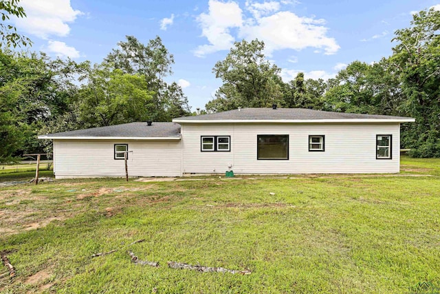 rear view of property featuring a lawn