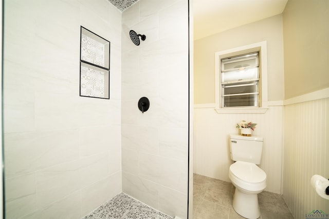 bathroom featuring toilet and a tile shower