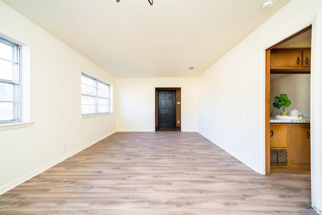 empty room featuring light wood-type flooring and a wealth of natural light