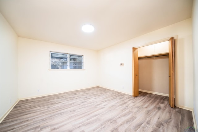 unfurnished bedroom with light wood-type flooring and a closet