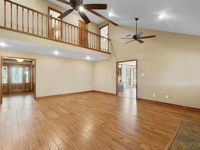 unfurnished living room featuring ceiling fan, high vaulted ceiling, and light hardwood / wood-style floors