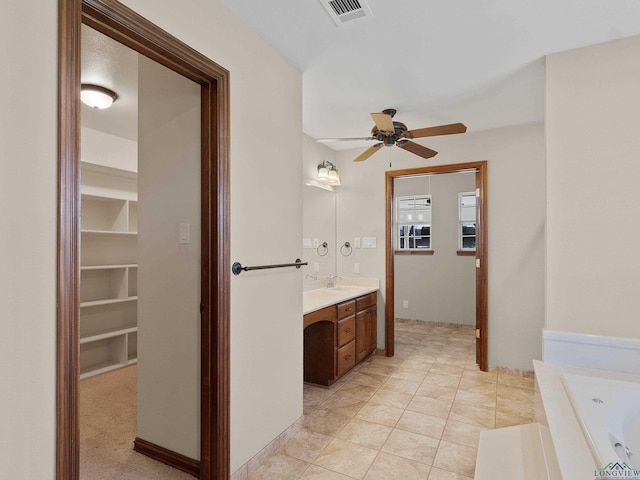 bathroom with tile patterned floors, vanity, ceiling fan, and a washtub