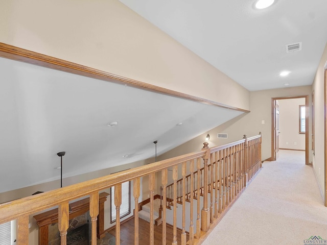 corridor with carpet floors and vaulted ceiling