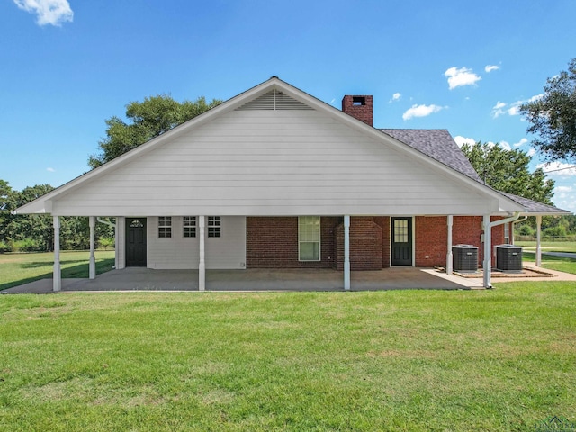 back of house featuring central AC unit, a patio area, and a yard