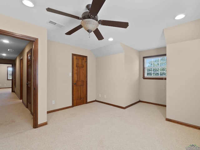 carpeted empty room with ceiling fan and vaulted ceiling