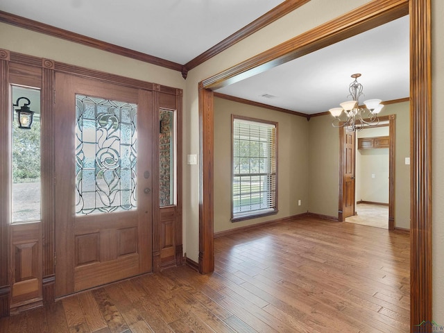 foyer featuring a chandelier, light hardwood / wood-style flooring, and ornamental molding