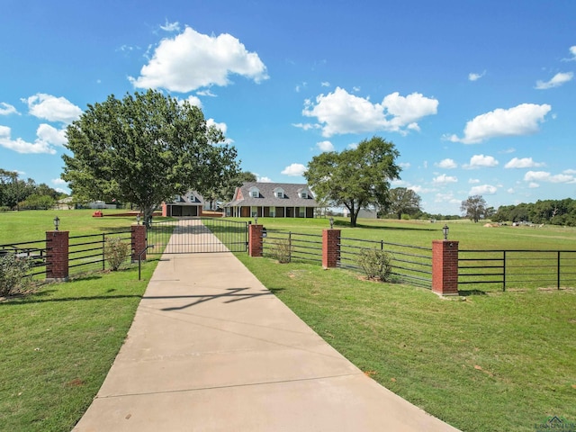 view of community featuring a rural view and a yard