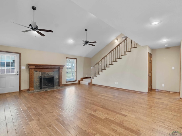 unfurnished living room featuring ceiling fan, a fireplace, and light hardwood / wood-style floors