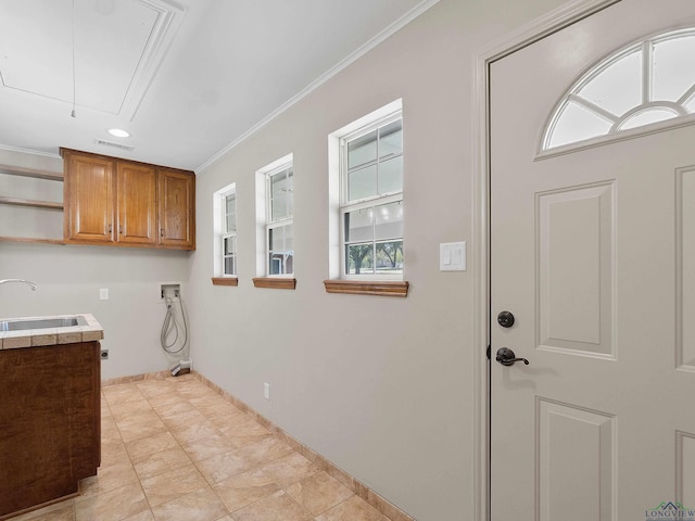 laundry room featuring cabinets, washer hookup, ornamental molding, sink, and light tile patterned floors