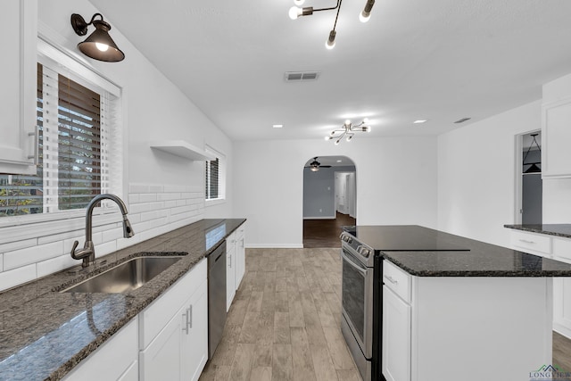 kitchen featuring white cabinetry, sink, dark stone countertops, and appliances with stainless steel finishes