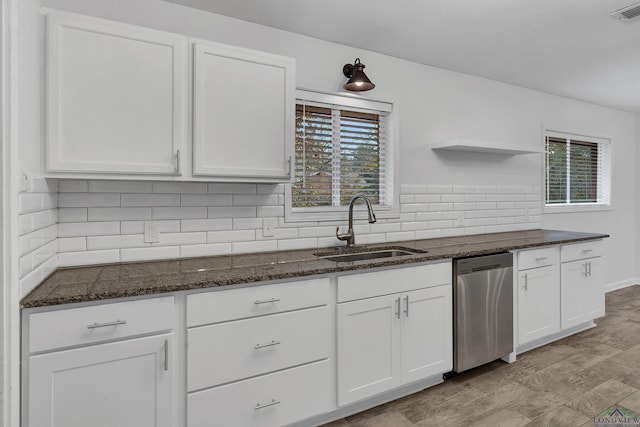 kitchen with sink, white cabinetry, tasteful backsplash, dark stone countertops, and dishwasher