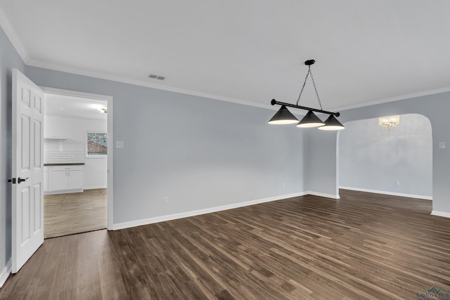 empty room with ornamental molding and dark hardwood / wood-style floors