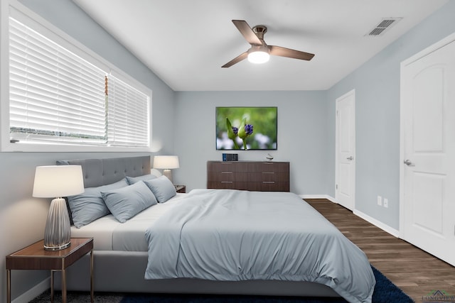 bedroom with dark hardwood / wood-style floors and ceiling fan