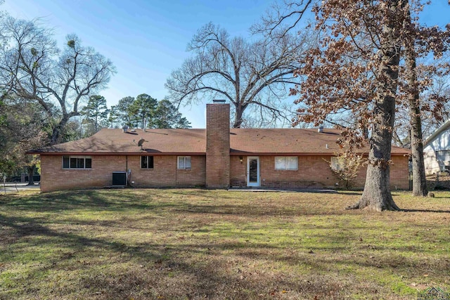 rear view of property featuring a yard and central AC unit