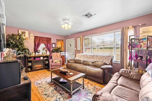 living room with ceiling fan and light hardwood / wood-style flooring