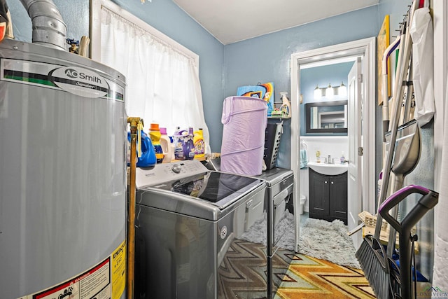 laundry area with independent washer and dryer, sink, and water heater