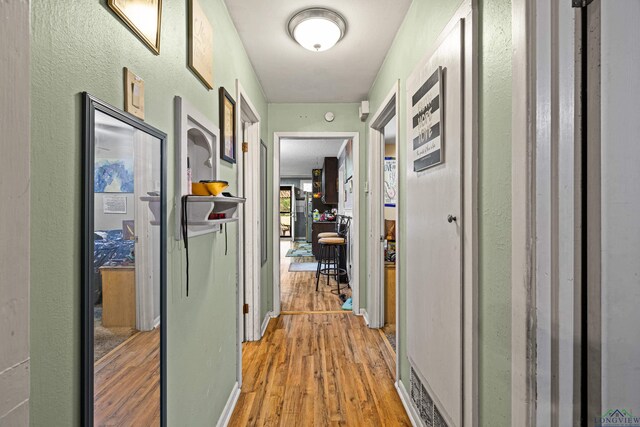 corridor with hardwood / wood-style flooring