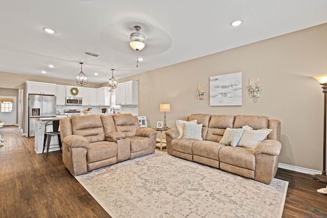 living room featuring dark hardwood / wood-style floors and ceiling fan