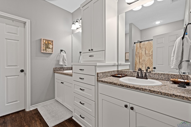 bathroom with hardwood / wood-style flooring, vanity, and curtained shower