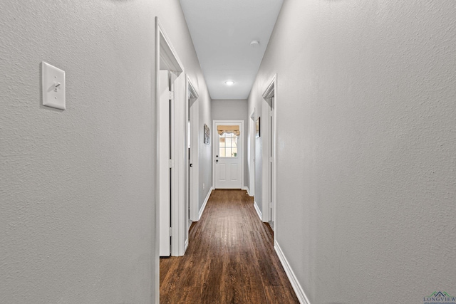 corridor with dark hardwood / wood-style flooring