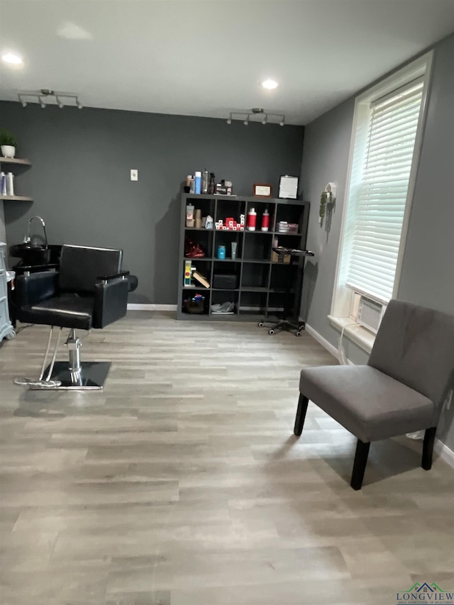 sitting room featuring cooling unit, rail lighting, and light hardwood / wood-style floors