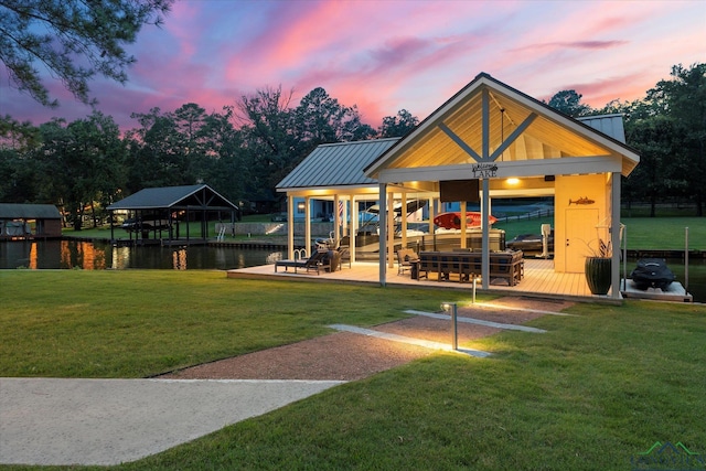 378 Cypress Creek Dr, Mount Vernon, TX 75457 - back of property at dusk with a water view, a lawn, and a metal roof