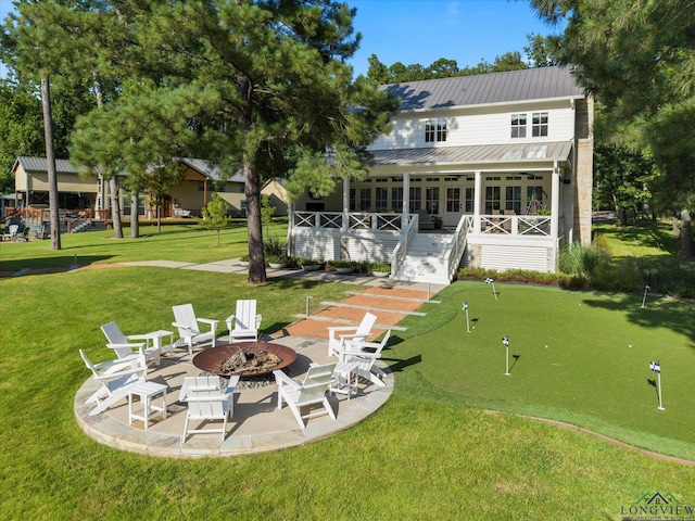 378 Cypress Creek Dr, Mount Vernon, TX 75457 - back of property featuring a putting area, an outdoor fire pit, a yard, a wooden deck, and a metal roof