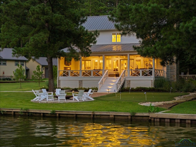 378 Cypress Creek Dr, Mount Vernon, TX 75457 - rear view of property with a water view, a putting area, a metal roof, a fire pit, and a patio area