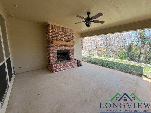 view of patio with an outdoor brick fireplace and ceiling fan