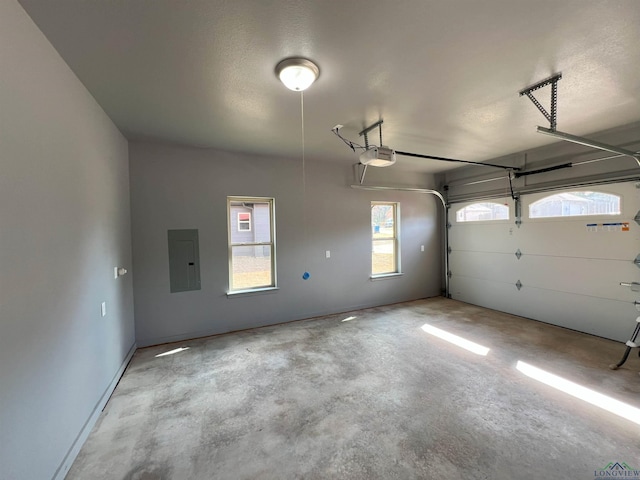 garage with a garage door opener and electric panel