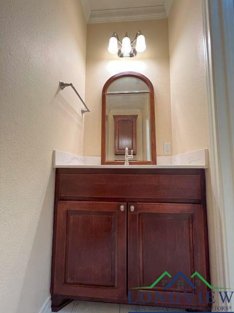 bathroom with ornamental molding and vanity