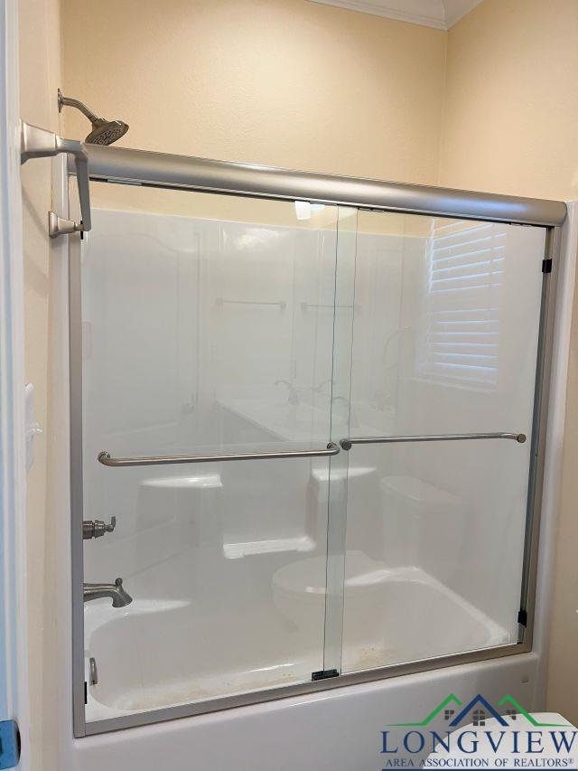 bathroom featuring bath / shower combo with glass door