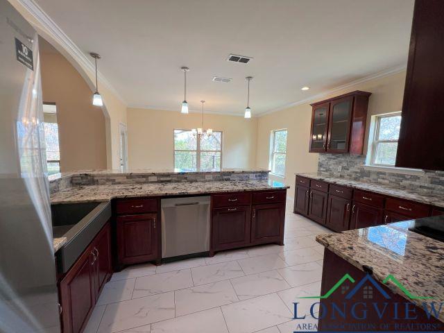 kitchen featuring crown molding, a chandelier, dishwasher, pendant lighting, and backsplash