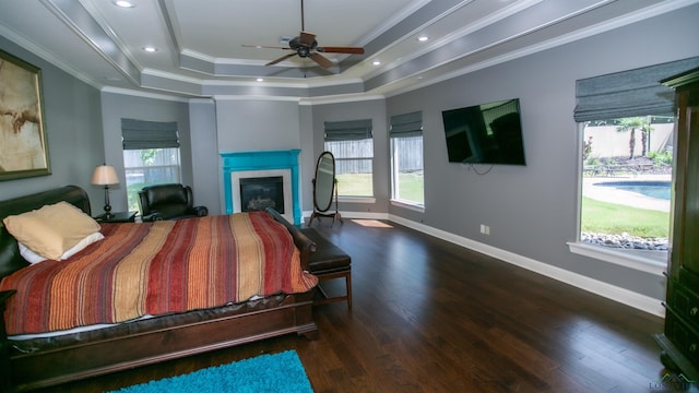 bedroom with a tray ceiling, crown molding, ceiling fan, and dark wood-type flooring