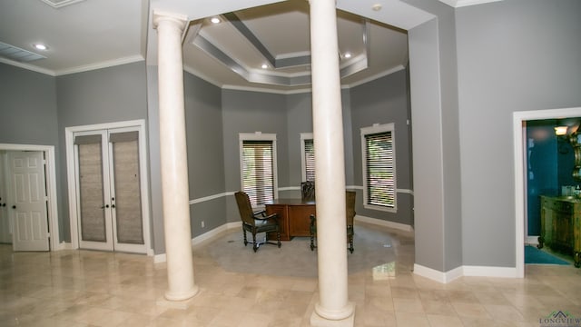 interior space featuring decorative columns, french doors, a towering ceiling, and ornamental molding