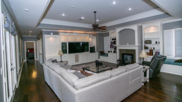 living room featuring ceiling fan, dark hardwood / wood-style flooring, built in features, and crown molding