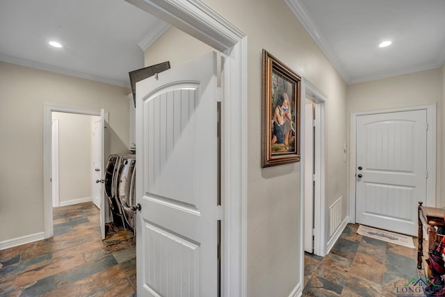 hall with ornamental molding and washing machine and clothes dryer