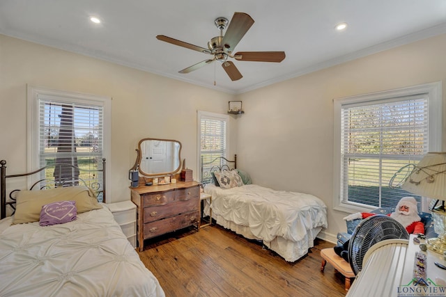 bedroom with ceiling fan, crown molding, and wood-type flooring