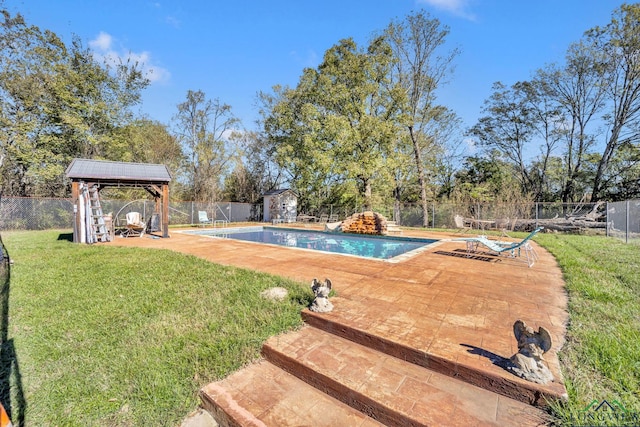 view of pool with a lawn, a patio area, a gazebo, and a shed