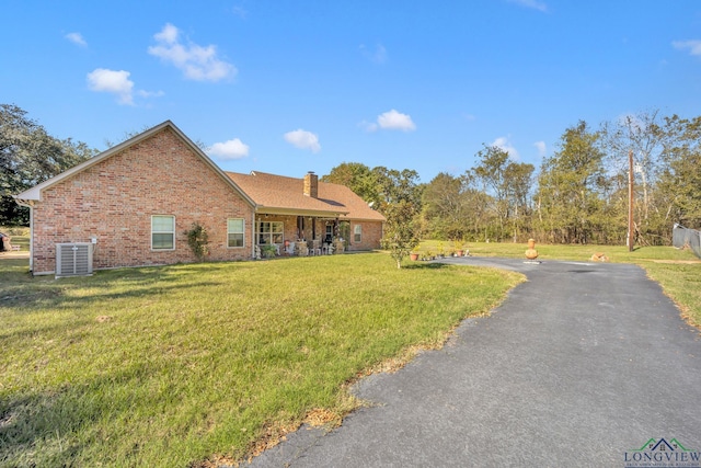 view of front of house featuring a front lawn and cooling unit