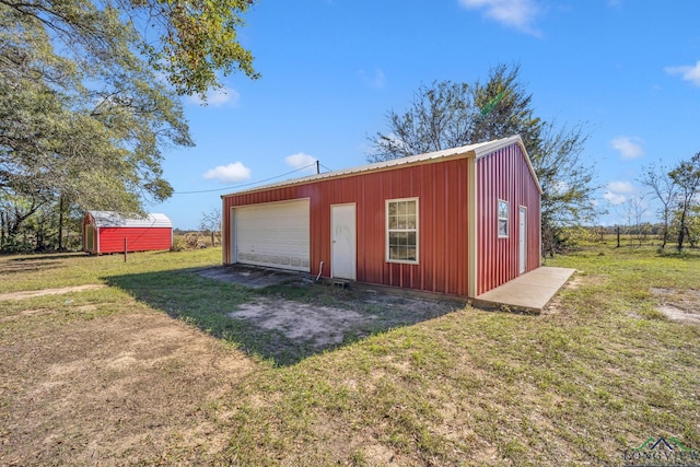 view of outbuilding with a garage and a lawn